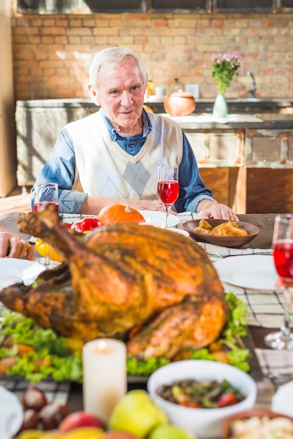 Bezpłatne zdjęcie osoby w podeszłym wieku człowiek siedzi przy stole z jedzeniem