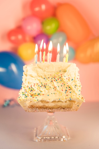 Bezpłatne zdjęcie oświetlone świeczki nad ciastem nad cakestand
