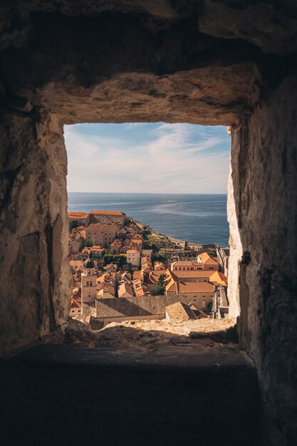 Otwór w ścianie z widokiem na panoramę miasta nad morzem