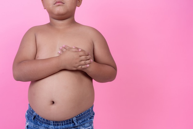 Bezpłatne zdjęcie otyły chłopiec z nadwagą na różowym tle.