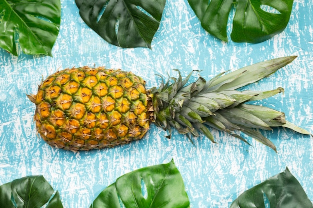 Bezpłatne zdjęcie owoc ananasa z liśćmi monstera