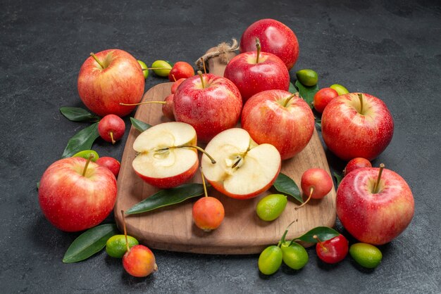 owoce jabłka i wiśnie z liśćmi na planszy obok owoców