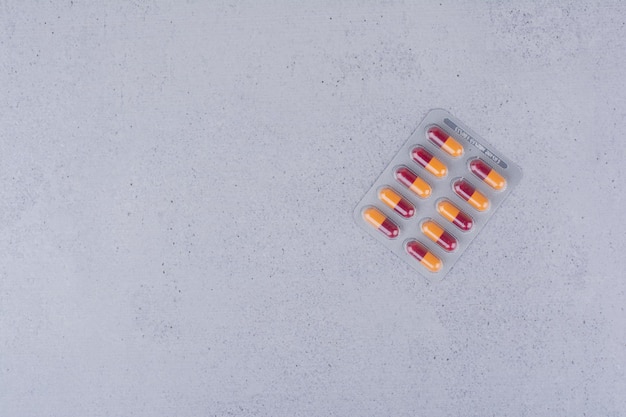 Bezpłatne zdjęcie paczka tabletek antybiotykowych na marmurowym tle. zdjęcie wysokiej jakości