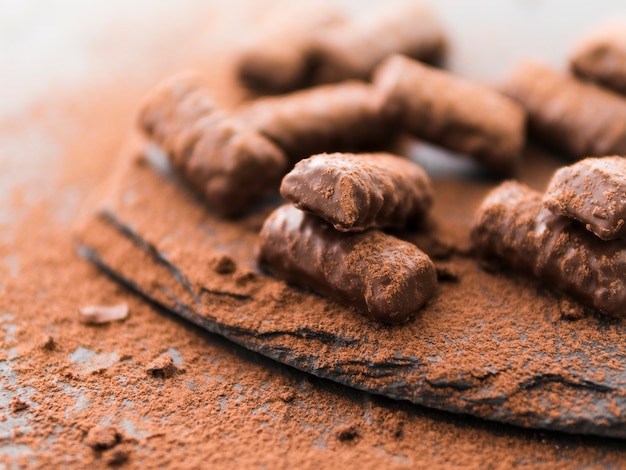 Pałeczki czekoladowe pokryte kakao na talerzu łupkowym