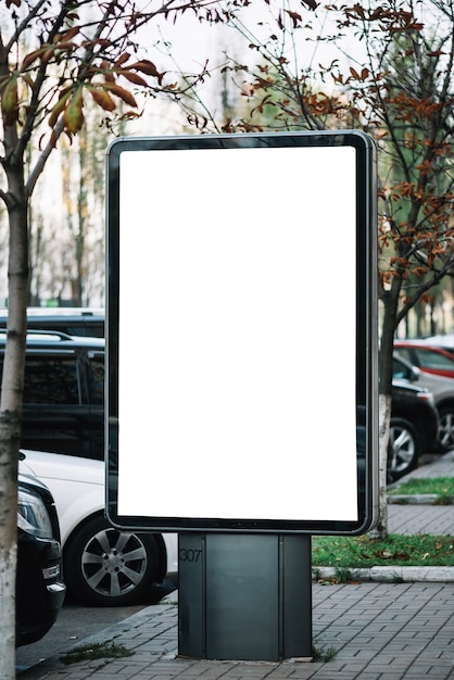 Bezpłatne zdjęcie panel reklamowy w pobliżu samochodów na parkingu