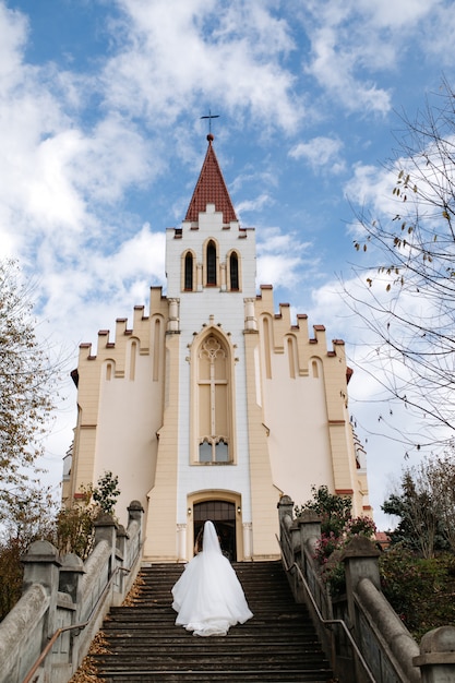 Panna młoda idzie po schodach do kościoła