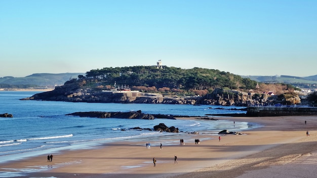 Panorama piaszczystej plaży z pasmem górskim i lasem tropikalnym