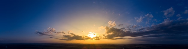 Panorama wschód słońca i ciemny poranek błękitne niebo. pochmurna pogoda o świcie z jasnym pomarańczowym światłem słonecznym