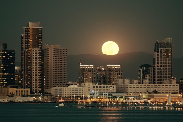 Panoramę centrum San Diego i księżyc w pełni nad wodą w nocy