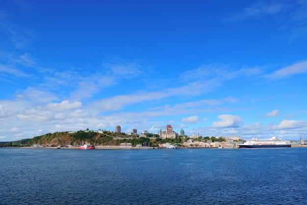 Panoramę miasta Quebec nad rzeką z niebieskim niebem i chmurą.