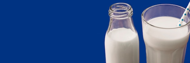 Bezpłatne zdjęcie panoramiczny widok mleko w butelce na błękitnym tle i szkle