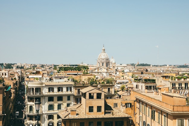 Panoramiczny widok na miasto rzym ze starymi domami z schodów hiszpańskich. letni słoneczny dzień i błękitne niebo