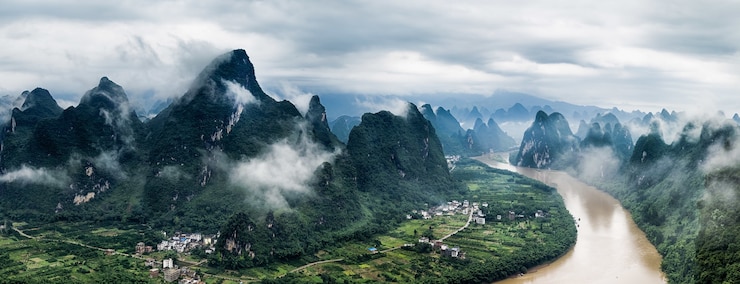 Bezpłatny plik Zdjęcie panoramiczny widok na rzekę li i górę mashan w hrabstwie yangshuo, guilin pod zachmurzonym niebem