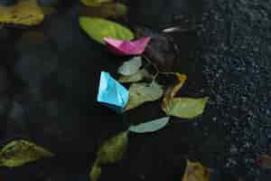 Bezpłatne zdjęcie papierowe łodzie w kałuży na zewnątrz w deszczową pogodę