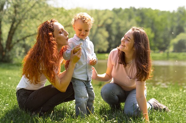 Para lesbijek spędzająca czas z dzieckiem w parku