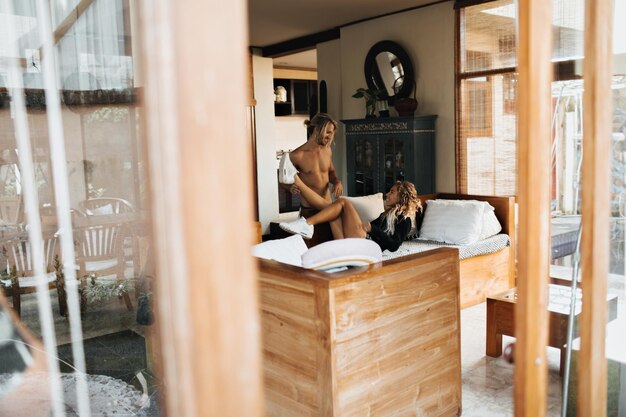 Para nowożeńców leżała na dużym łóżku pokoju hotelowego w orientalnym stylu ozdobionym egzotycznymi meblami