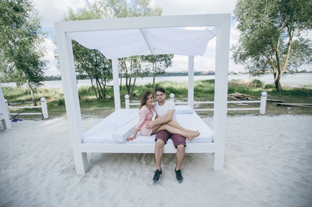 Para obejmując na podwójnym łóżkiem na plaży