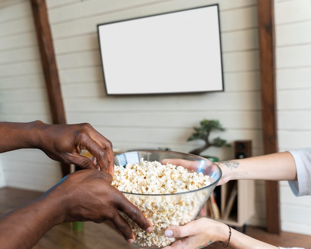 Bezpłatne zdjęcie para ogląda film podczas jedzenia popcornu