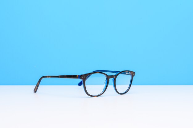 Para okularów na białej powierzchni na niebieskim tle