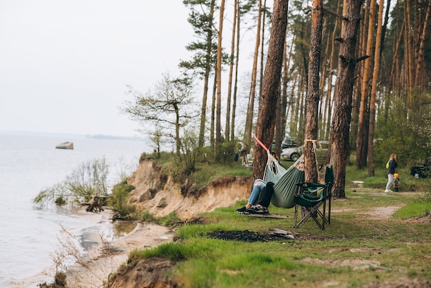 Para relaksuje się w hamaku z widokiem na wodę