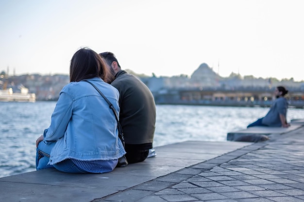 Para siedząca na brzegu portu morskiego w Stambule i ciesząca się widokiem