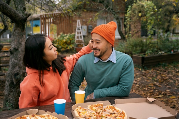 Bezpłatne zdjęcie para średniego strzału z pyszną pizzą?