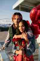 Bezpłatne zdjęcie para trzymająca balony w kształcie serca podczas randki