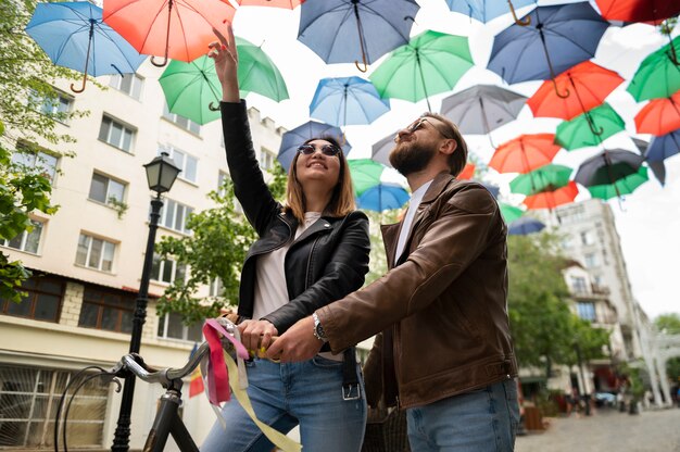 Para W Kurtkach Ze Skóry Syntetycznej Przechodząca Pod Kolorowymi Parasolami Na Zewnątrz