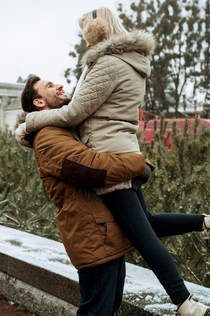 Bezpłatne zdjęcie para w zimie trzymając razem na zewnątrz
