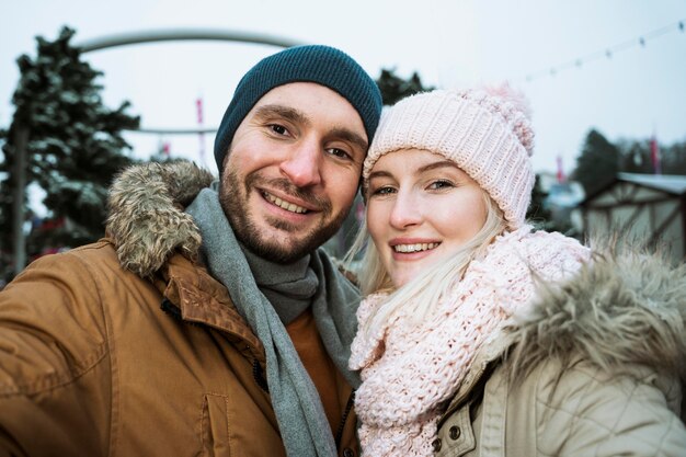 Para w zimie uśmiechając się do kamery