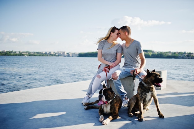 Para zakochana w dwóch psach pit bull terrier na plaży