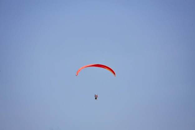 Paralotniarstwo na niebie Paralotnia latająca w jasny słoneczny dzień Piękna paralotnia w locie na turkusowym tle