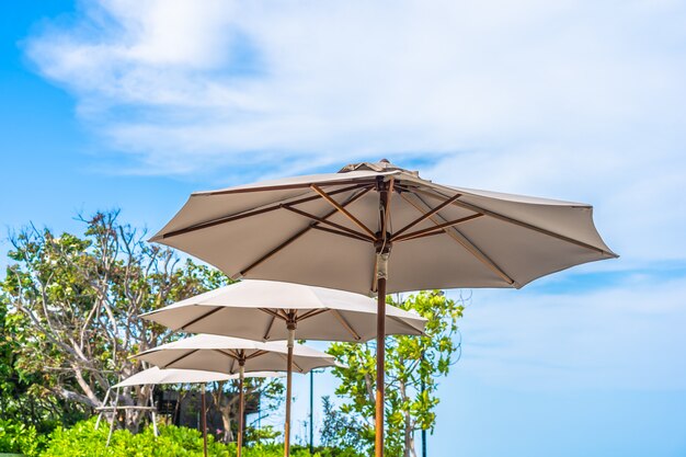 Parasol i krzesło na plażowym dennym oceanie z niebieskim niebem i biel chmurą