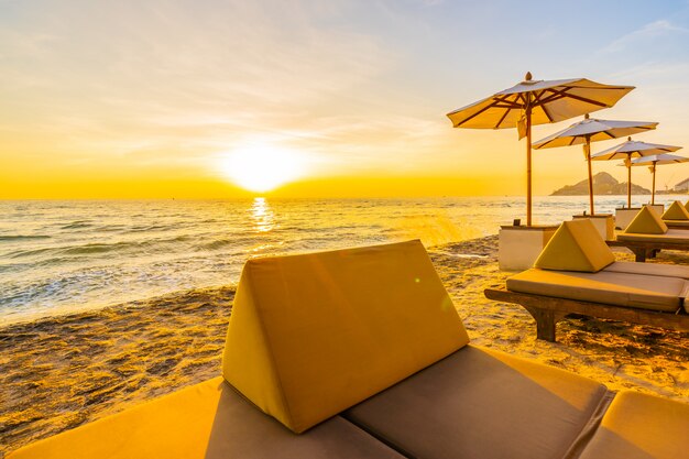 Parasol i krzesło z poduszką wokół pięknego krajobrazu plaży i morza
