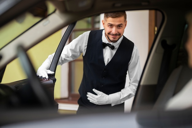 Bezpłatne zdjęcie parkingowy opiekujący się pojazdem klienta