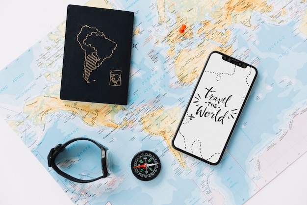 Bezpłatne zdjęcie paszport; zegarek na rękę; kompas i telefon komórkowy z wiadomością podróż na białym ekranie