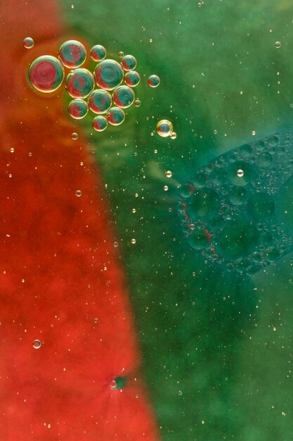 Pęcherzyki oleju pływające na czerwony i zielony kolor farby wodnej