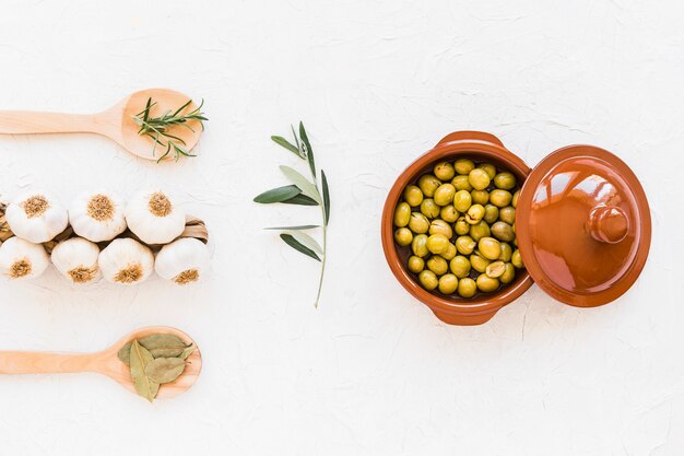 Pęczek cebul czosnkowych z ziołami i świeżymi zielonymi oliwkami