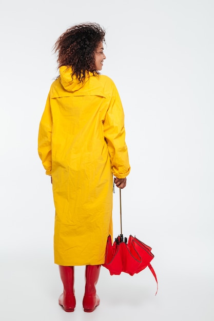 Bezpłatne zdjęcie pełna długość widok z tyłu obraz afrykańskiej kobiety w płaszczu