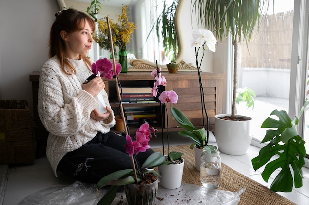 Bezpłatne zdjęcie pełna strzał młoda kobieta z orchideą