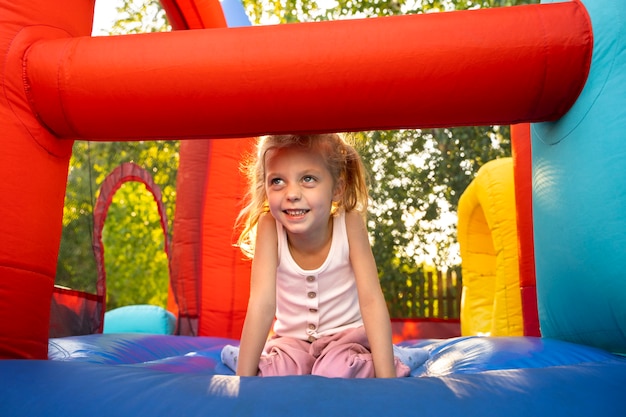 Pełna uśmiechnięta dziewczyna w bounce house