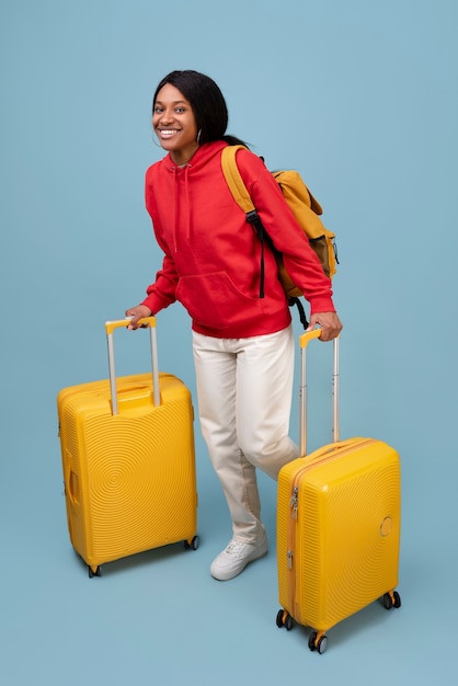 Pełna uśmiechnięta kobieta z żółtym bagażem