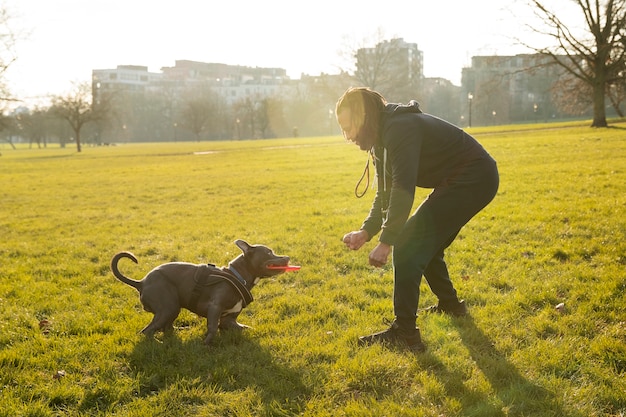 Bezpłatne zdjęcie pełne ujęcie człowieka bawiącego się z psem na zewnątrz