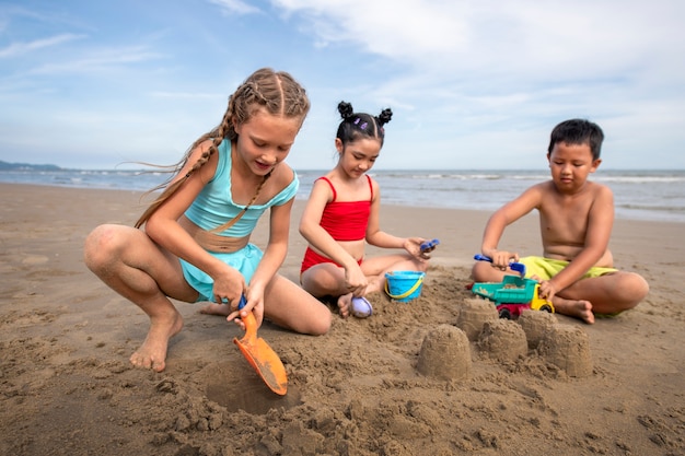 Pełne ujęcie dzieci bawiące się piaskiem