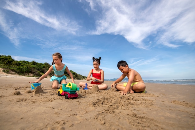 Bezpłatne zdjęcie pełne ujęcie dzieci bawiących się na plaży?