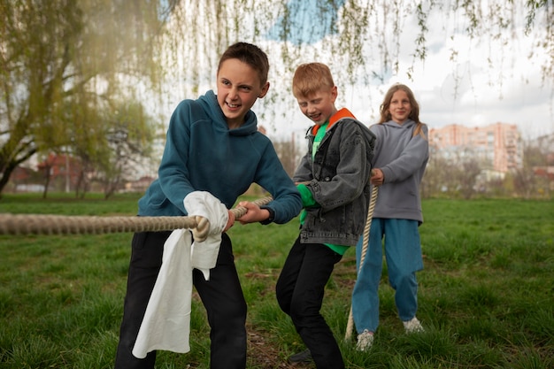 Pełne ujęcie dzieci bawiących się w przeciąganie liny w parku