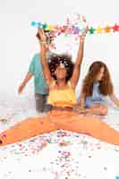 Bezpłatne zdjęcie pełne ujęcie dzieci z kolorowym konfetti
