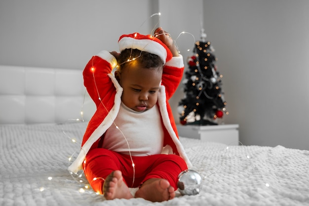 Pełne ujęcie dziecka bawiące się lampkami bożonarodzeniowymi