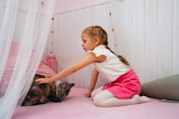 Pełne ujęcie dziewczyny bawiącej się z kotem