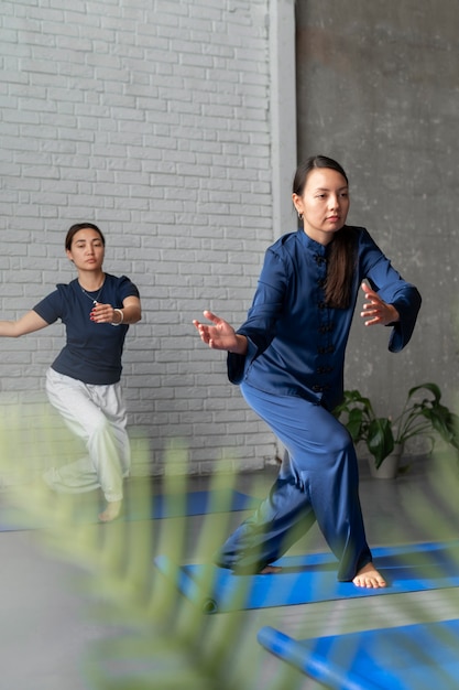 Bezpłatne zdjęcie pełne ujęcie kobiet ćwiczących razem tai chi